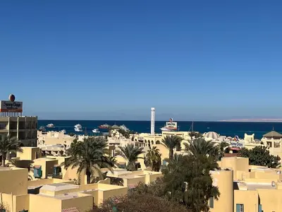 a city with buildings and palm trees and the ocean at Benashti Hurghada apartment in Hurghada