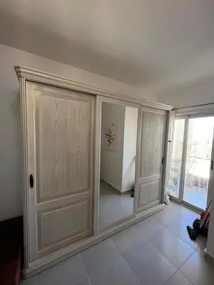 a living room with white cabinets and a window at Benashti Hurghada apartment in Hurghada