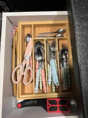 a wooden drawer with utensils in a box at Benashti Hurghada apartment in Hurghada