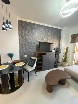 a living room with a table and a tv at Benashti Hurghada apartment in Hurghada