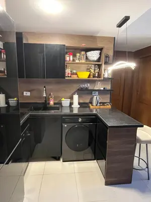 a kitchen with black cabinets and a dishwasher at Benashti Hurghada apartment in Hurghada