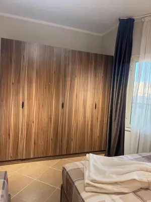 a bedroom with a wooden wall and a bed at Balkan Beach Resort- Relaxing Beach Apartment in Hurghada