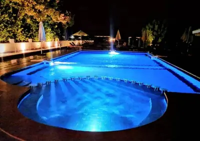 a large blue swimming pool at night at Balkan Beach Resort- Relaxing Beach Apartment in Hurghada