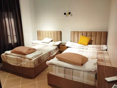 a room with two beds and a table at Balkan Beach Resort- Relaxing Beach Apartment in Hurghada