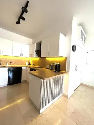 a kitchen with white cabinets and a counter top at Luxury 2BR Sea View Apt in Azzurra Sahl Hasheesh in Hurghada