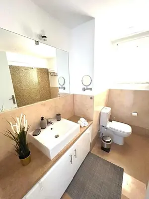a bathroom with a sink and a toilet and a mirror at Luxury 2BR Sea View Apt in Azzurra Sahl Hasheesh in Hurghada