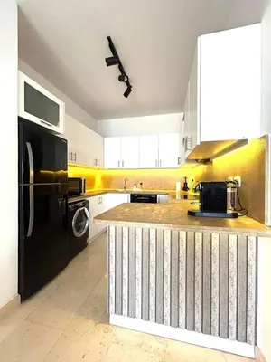 a kitchen with a black refrigerator and a counter at Luxury 2BR Sea View Apt in Azzurra Sahl Hasheesh in Hurghada