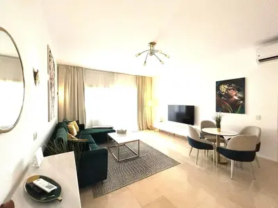 a living room with a green couch and a table at Luxury 2BR Sea View Apt in Azzurra Sahl Hasheesh in Hurghada