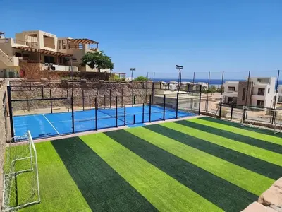 a swimming pool with grass and a goal at Luxury 2BR Sea View Apt in Azzurra Sahl Hasheesh in Hurghada