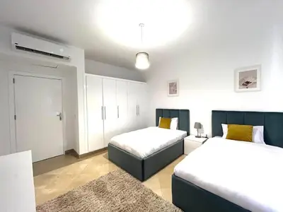 a bedroom with two beds and a rug at Luxury 2BR Sea View Apt in Azzurra Sahl Hasheesh in Hurghada
