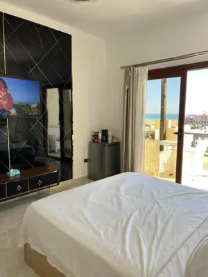 a bedroom with a large bed and a large window at Appartement hurghada gravity beach in Hurghada