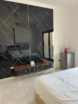 a bedroom with a bed and a tv on a wall at Appartement hurghada gravity beach in Hurghada