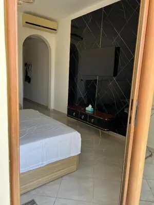 a bedroom with a bed and a flat screen tv at Appartement hurghada gravity beach in Hurghada