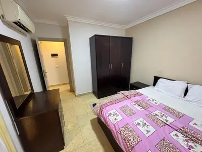a bedroom with a bed and a dresser in it at 2 bedroom furnished apartment in Hurghada