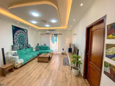 a living room with a green couch and a table at Bright 2BR & Office, Remote Work Ready & Long Stays in Hurghada