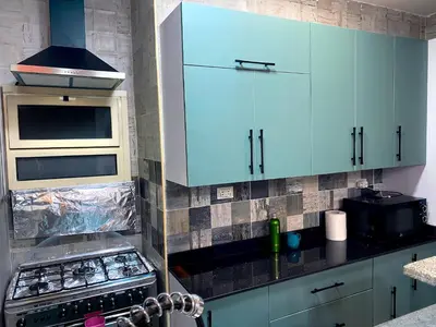 a kitchen with blue cabinets and a stove at Bright 2BR & Office, Remote Work Ready & Long Stays in Hurghada