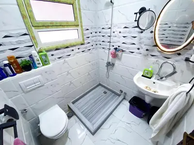 a white bathroom with a sink and a toilet at Bright 2BR & Office, Remote Work Ready & Long Stays in Hurghada