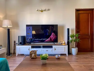 a living room with a flat screen tv on a white entertainment center at Bright 2BR & Office, Remote Work Ready & Long Stays in Hurghada