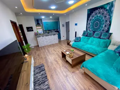 a living room with a green couch and a table at Bright 2BR & Office, Remote Work Ready & Long Stays in Hurghada