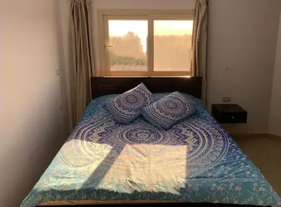 a bed with pillows on it with a window at Arietta Flat Amazing location in Avrio compound in Hurghada