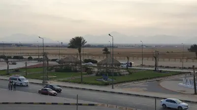 a street with cars parked on the side of a road at Arietta Flat Amazing location in Avrio compound in Hurghada