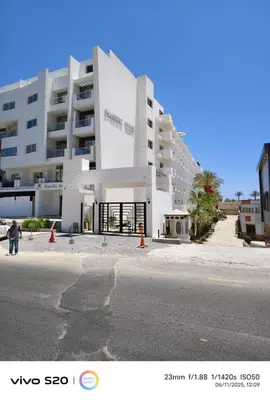 a large white building on the side of a street at Scandic Resort in Hurghada