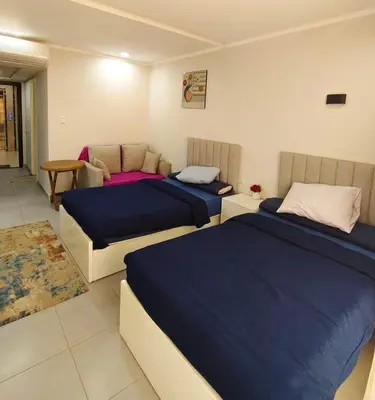 a bedroom with two beds and a table at Scandic Resort in Hurghada