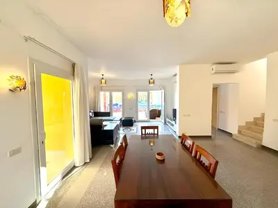 a living room with a wooden table and chairs at Stunning Pool and Sea View Villa, Al Dora Resort, Hurghada in Hurghada