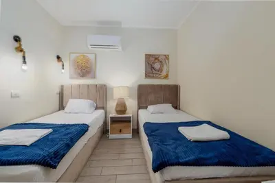 two beds in a small room with blue sheets at Exclusive Heated Pool Chalet for a Luxury in Hurghada