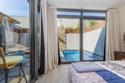 a bedroom with a view of a swimming pool through a window at Exclusive Heated Pool Chalet for a Luxury in Hurghada