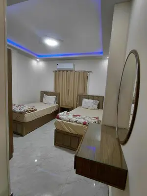 two beds in a room with a mirror and a table at شقق للايحار وشقق للبيع داخل الغردقه in Hurghada