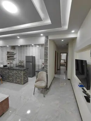 a large living room with a television and a chair at شقق للايحار وشقق للبيع داخل الغردقه in Hurghada