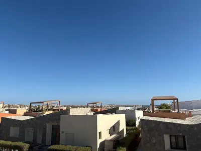 a view of some buildings with the ocean in the background at Luxury 2 BR Villa with garden - Baywest - somabay in Hurghada
