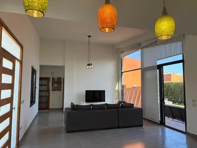 a living room with a couch and a tv at Luxury 2 BR Villa with garden - Baywest - somabay in Hurghada