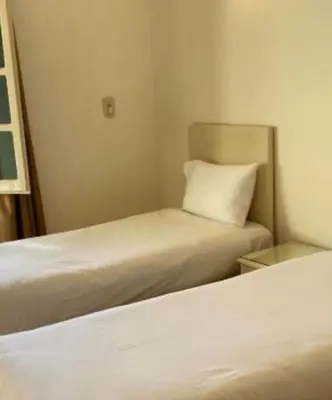 two beds in a small room with a pillow on it at Family Hotel Luxor in Luxor
