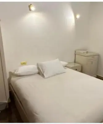 a white bed with two pillows in a room at Family Hotel Luxor in Luxor