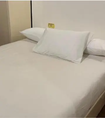 a white bed with white pillows and a white pillow at Family Hotel Luxor in Luxor