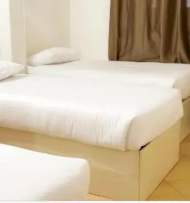 two beds in a room with white sheets at Family Hotel Luxor in Luxor