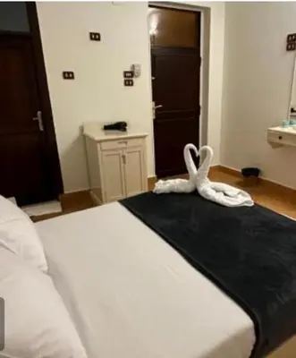 a bedroom with a bed with white towels on it at Family Hotel Luxor in Luxor