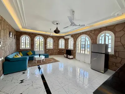 a living room with a blue couch and a tv at Nile Palace Villa in Luxor