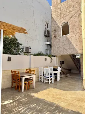 a patio with tables and chairs and a building at Nile Palace Villa in Luxor