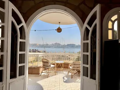 an archway leading to a patio with a table and chairs at Nile Palace Villa in Luxor