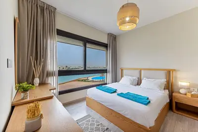 a bedroom with a large bed and a large window at Amazing Sunset View Apartment with modern style in Hurghada