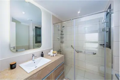 a bathroom with a sink and a glass shower at Amazing Sunset View Apartment with modern style in Hurghada