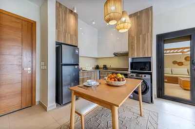 a kitchen with a table with a bowl of fruit on it at Amazing Sunset View Apartment with modern style in Hurghada