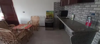 a kitchen with a counter and chairs and a table at Apartment with Balcony in Luxor