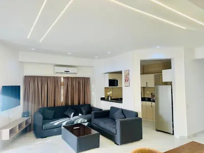 a living room with a blue couch and a refrigerator at Sky Villa in Hurghada