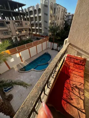a hand on a balcony looking at a swimming pool at Barbara Hurghada in Hurghada