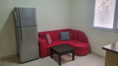 a red couch in a kitchen with a refrigerator at Barbara Hurghada in Hurghada