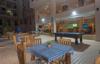 a restaurant with a pool table and tables and chairs at Aqua Tropical Apartment Near El Gouna in Hurghada